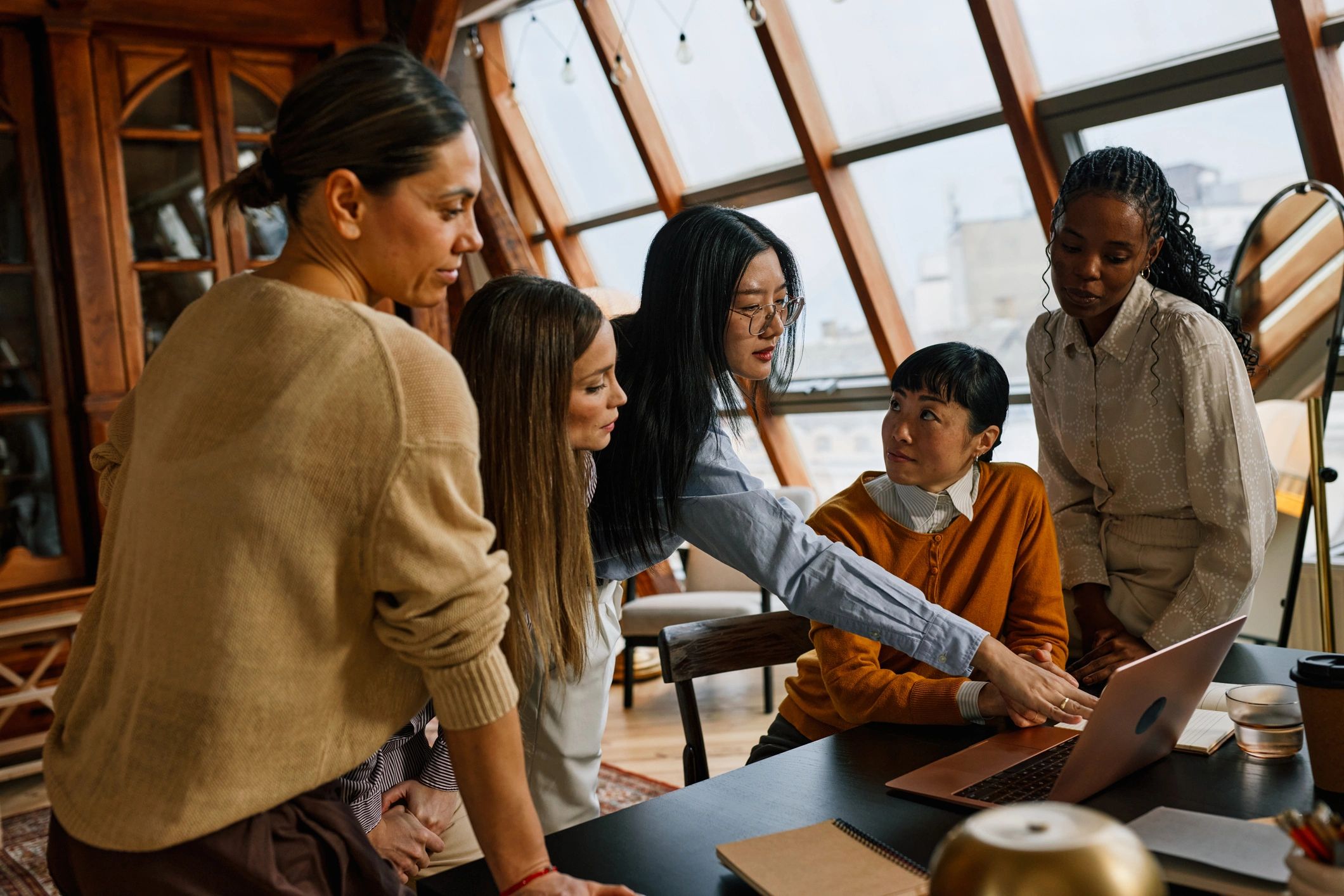 Marketing team collaborating around a laptop